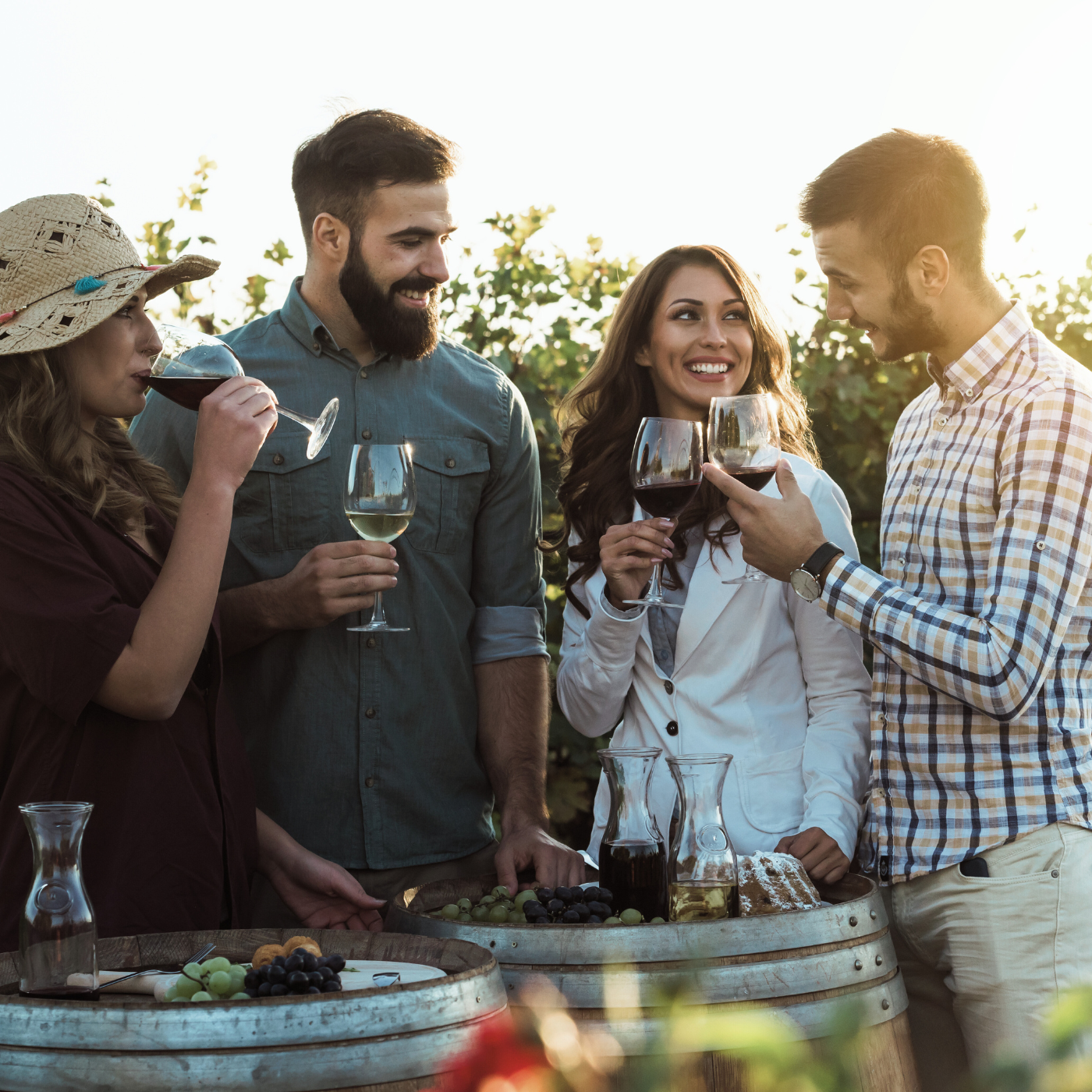 Fröhliche Freunde genießen zusammen Wein im Weinberg. Freundschaft mit jungen Menschen, die gemeinsam Wein genießen. 
